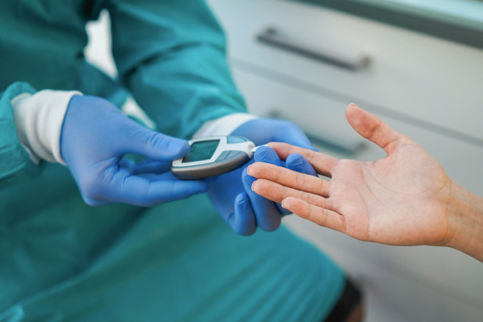 Healthcare professional taking a patient's blood sugar