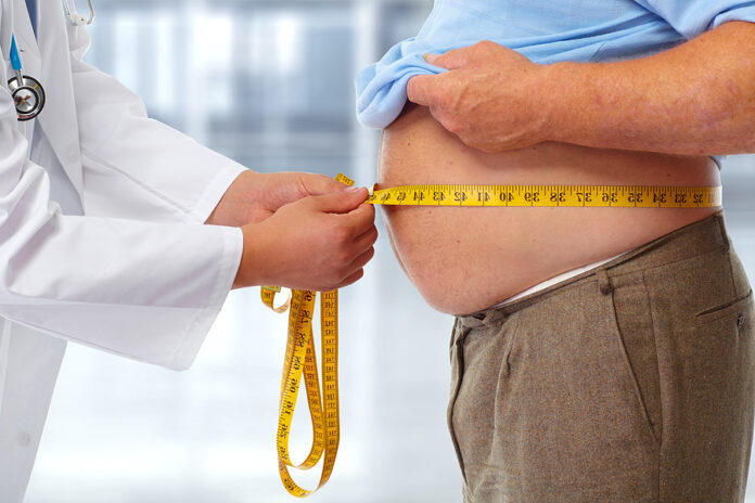 Doctor measuring obese man at the waist